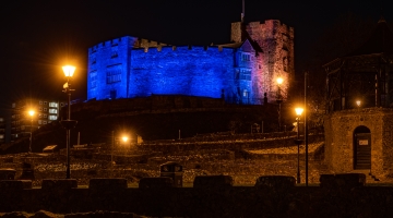 Image of Tamworth Castle at night, lit-up blue and yellow