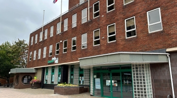 The outside of Marmion House. The council brick building with lots of windows and green doors.